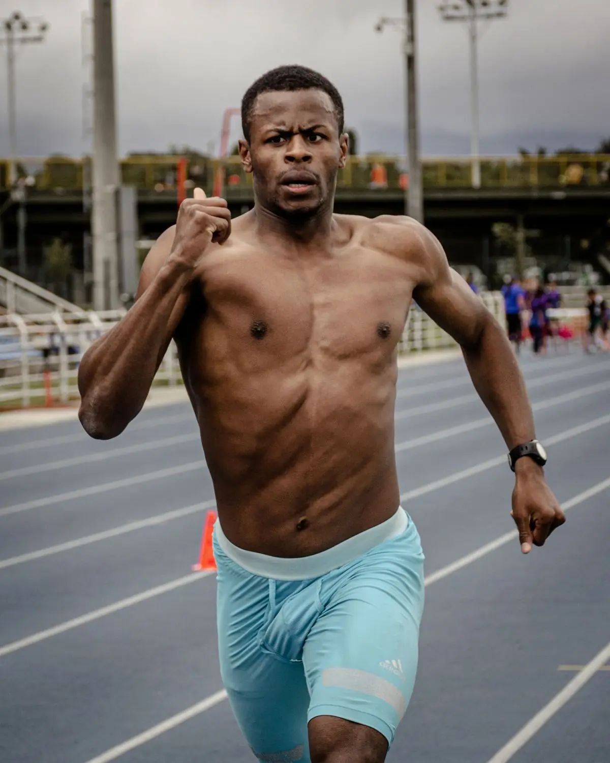 Muscular male athlete sprinting on a track in Bogotá.