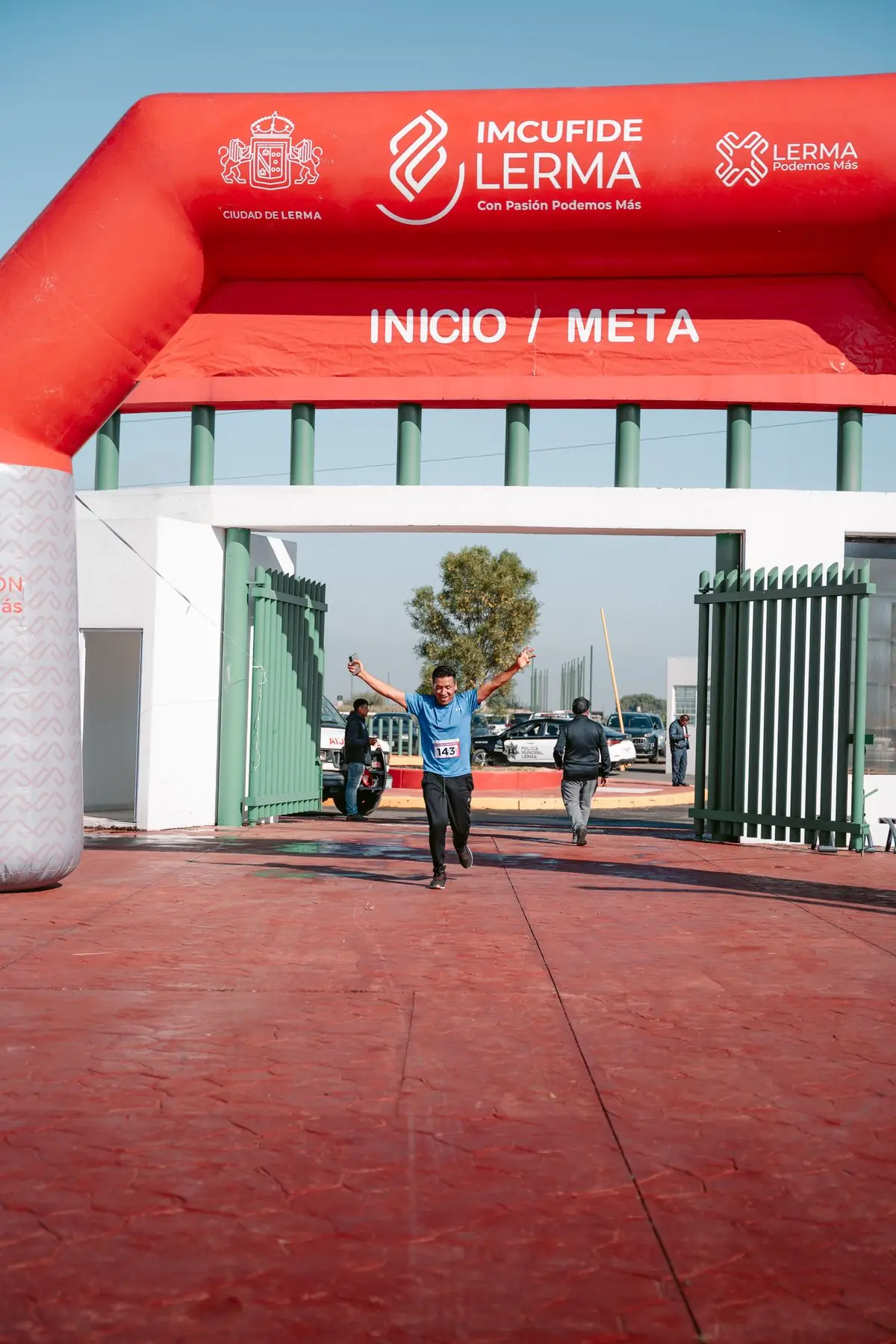Athlete triumphantly crossing the finish line during an outdoor marathon race.