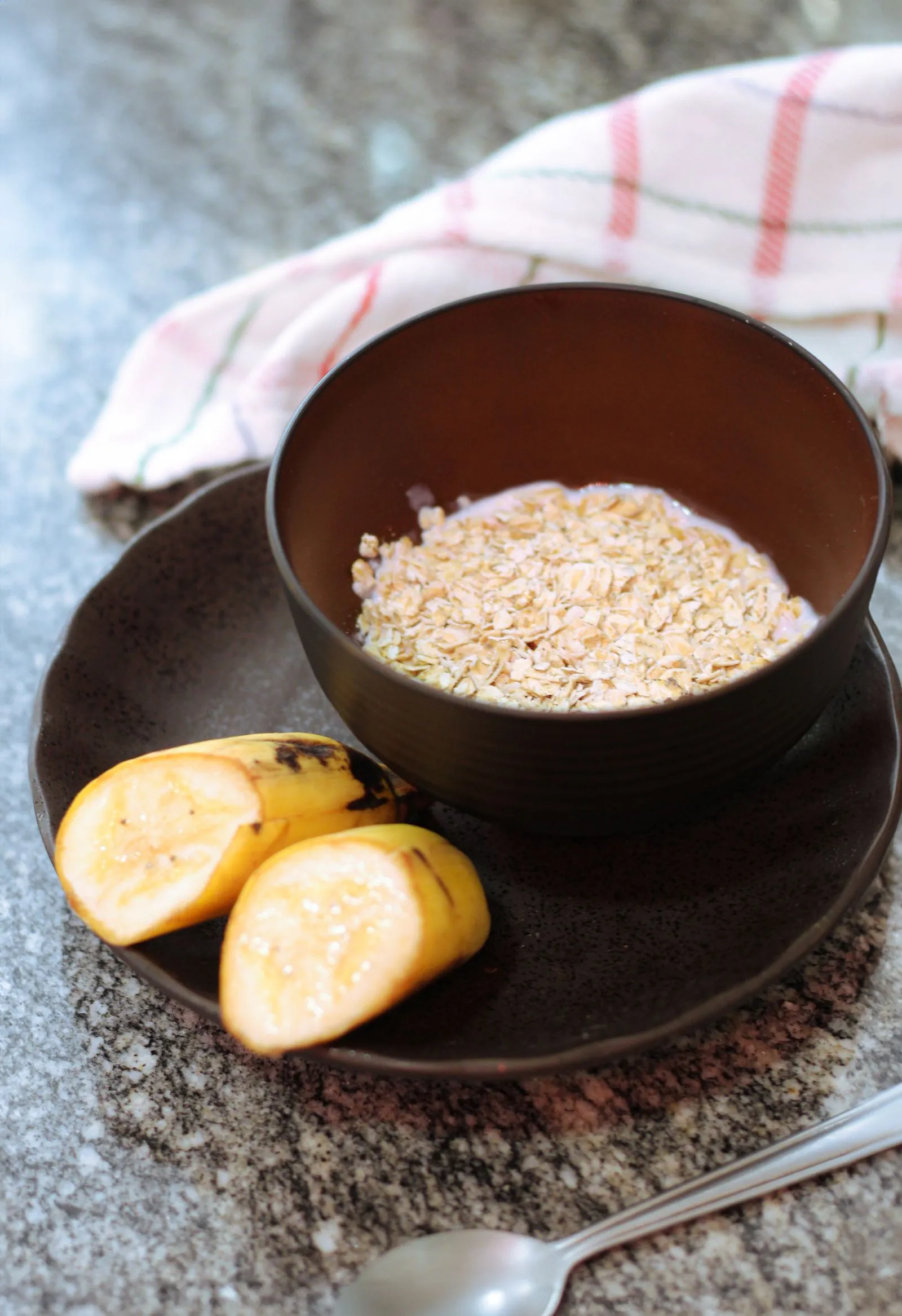 A banana beside a bowl of porridge