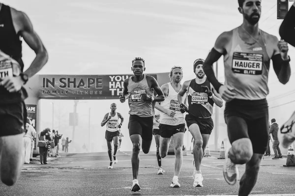 Black and white photo of intense marathon runners nearing the finish line under a large banner. ... Athlete Athletic Competition Athletic Event Athletics Black And White City Marathon Competition Competitive Running Crowd Determination Distance Running Elite Athletes Endurance Endurance Challenge Endurance Sport Event Finish Line Finish Line Banner Fitness Focus Group Of Runners Headband Health Intensity Journey Long Distance Running Marathon Marathon Banner Marathon Crowd Marathon Finish Outdoor Event Outdoor Running Public Event Race Race Banner Race Day Runners Running Running Gear Running Race Sport Sport Event Sweat Track And Field Training Urban Environment Urban Race.