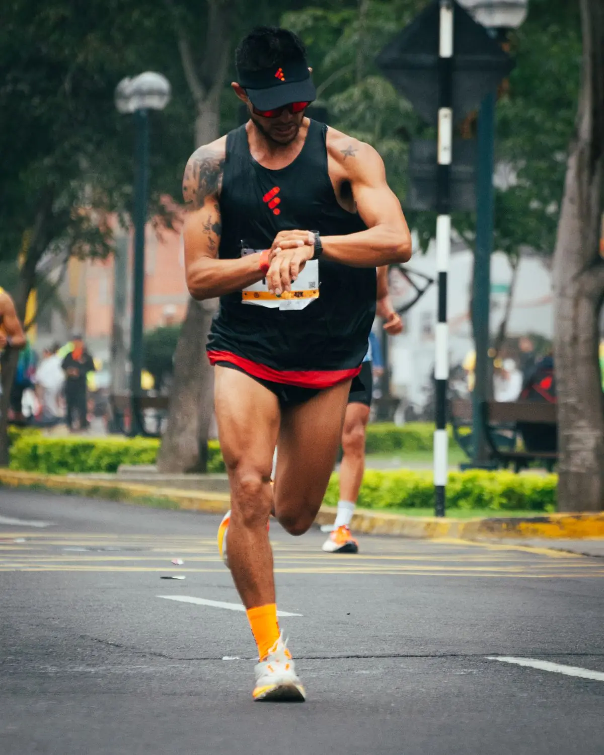 Athlete checks watch while running a marathon in Peru.