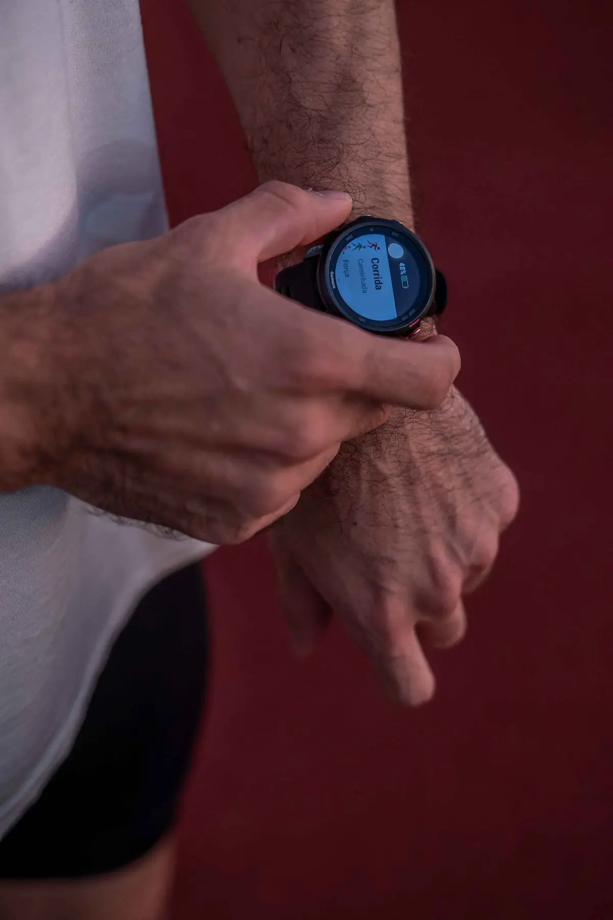 A man checks his smartwatch after a run on an outdoor track in Foz do Iguaçu.