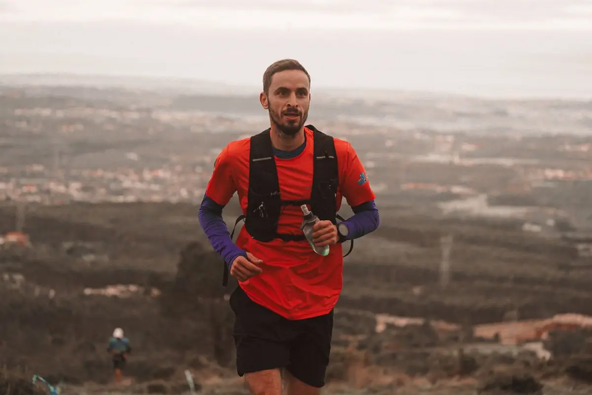 Man running on a scenic mountain trail with a breathtaking landscape view.