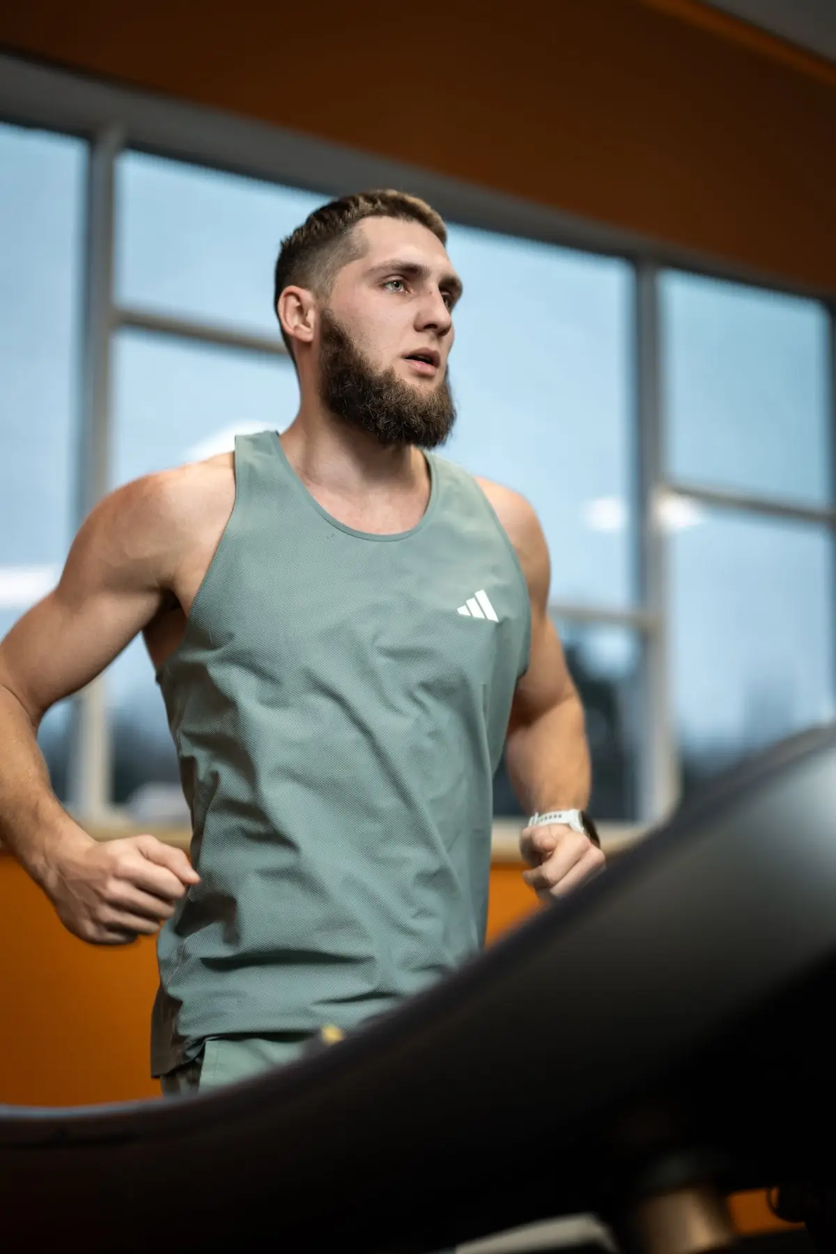 Athletic bearded man running on a treadmill.