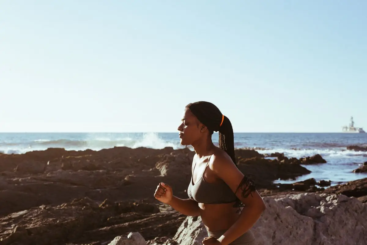 Fit woman running by the ocean.