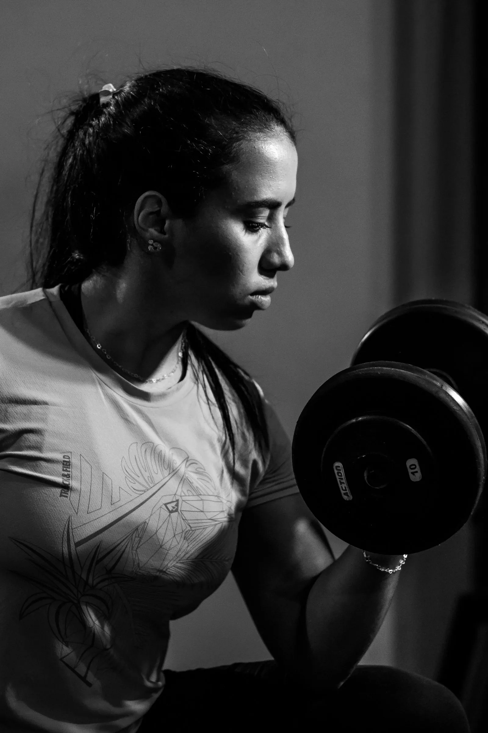 A woman lifting a dumbbell in a gym